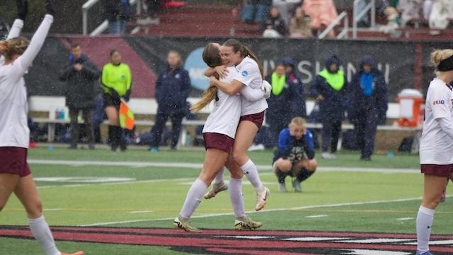 Two Franklin Pierce players embrace after a big DII women's soccer tournament win.